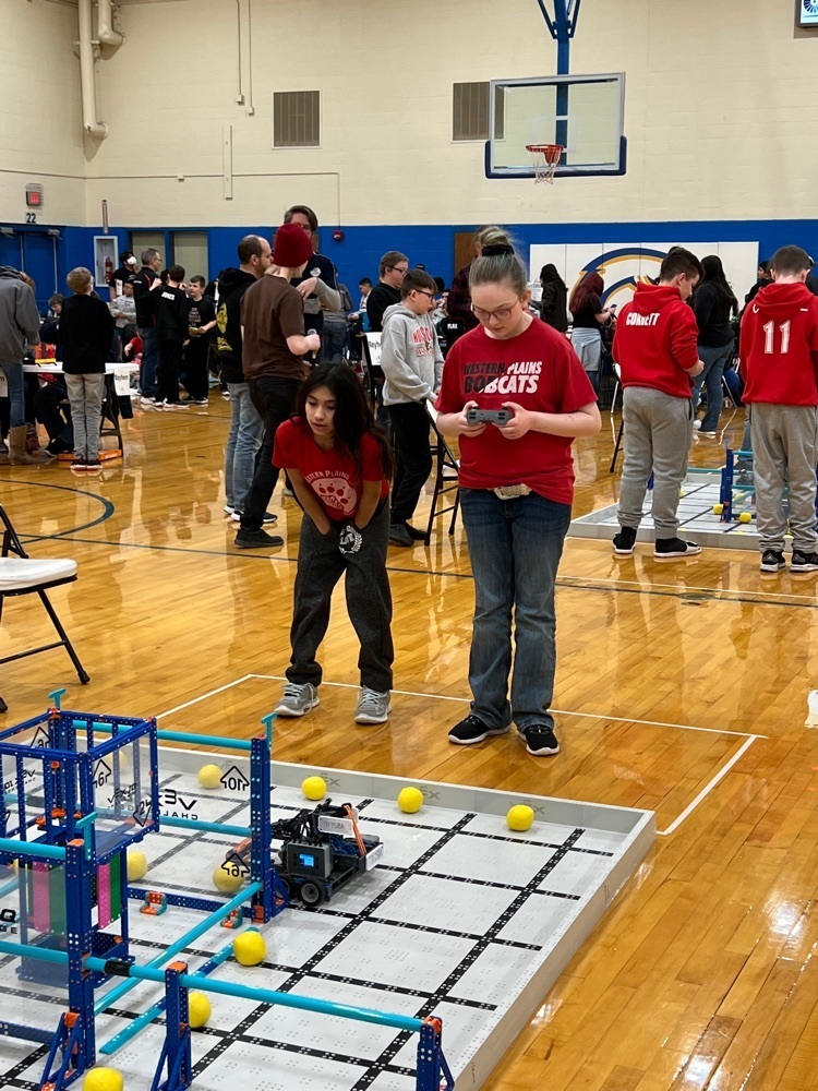students are driving their robot to score during a team work challenge.